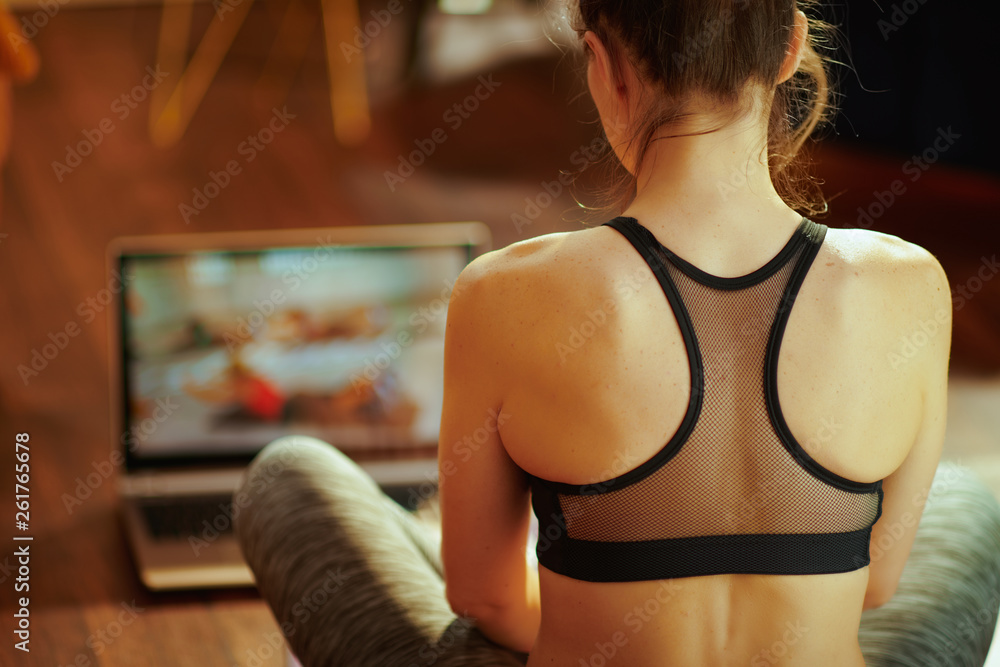 sports woman and using online fitness training program in laptop