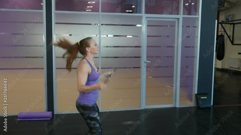 Energetic fitness girl jumping a skipping rope in fitness wellness studio gym. Energetic fitness girl jumping a skipping rope in fitness wellness studio gym.
