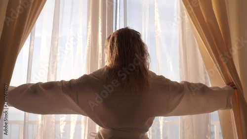 girl opens the curtains