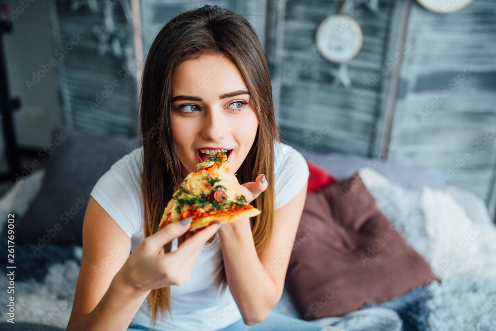 Young beautiful girl eat pizza in ger room