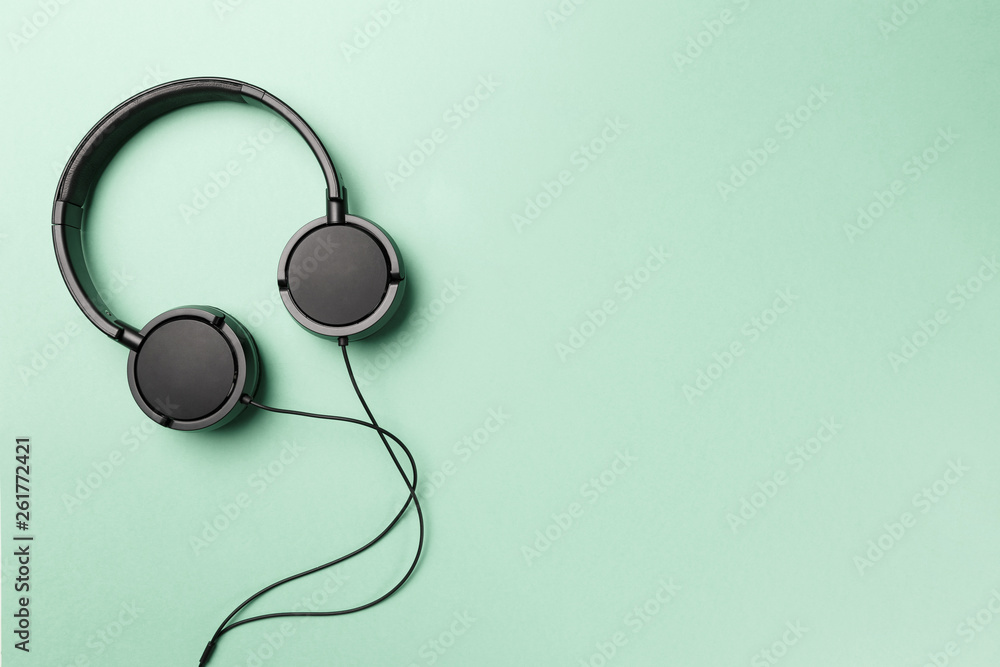 Headphones on Mint background. Black headphones on a pastel background. Top  view. Flat lay. Copy space. Minimal style with colorful paper backdrop.  Music concept. Neo Mint color of the year 2020 Stock