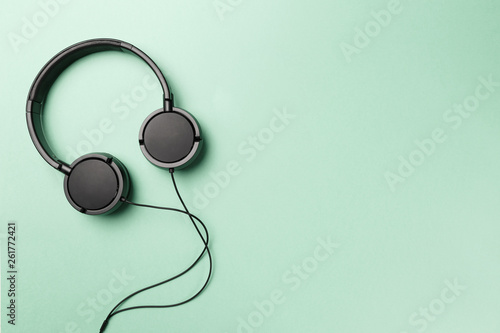 Headphones on Mint background. Black headphones on a pastel background. Top view. Flat lay. Copy space. Minimal style with colorful paper backdrop. Music concept. Neo Mint color of the year 2020
