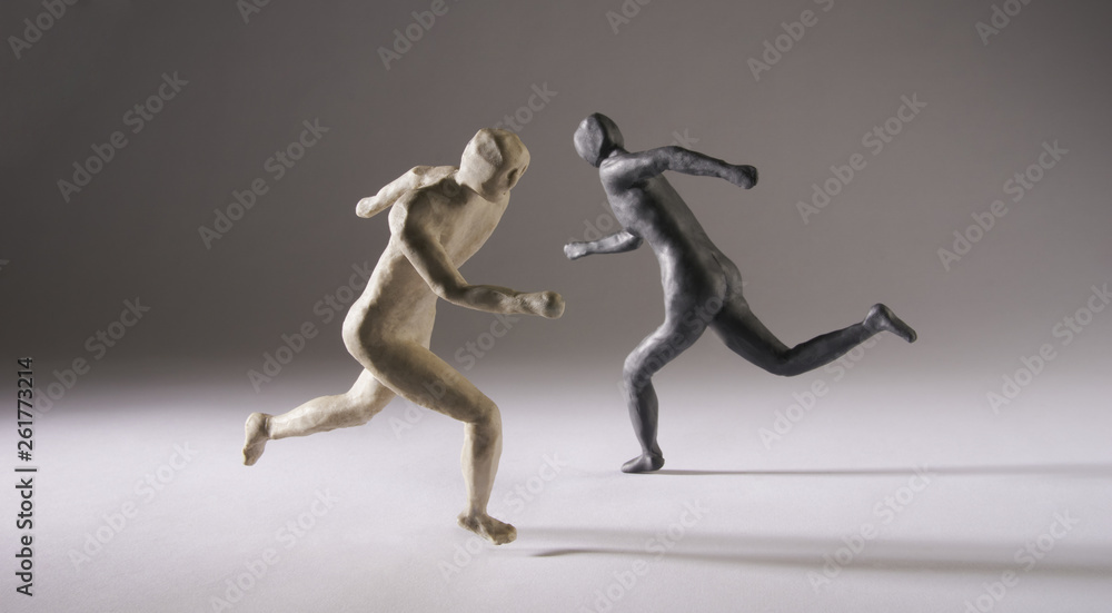 Black and white men run in different directions. With space copy text. Isolated on grey background. Studio Shot. Black and white men run in different directions. With space copy text. Isolated on grey background. Studio Shot.