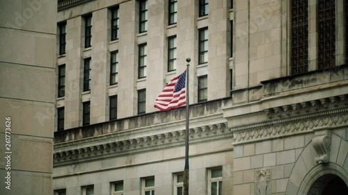 American flag super slow motion waves in wind against stone government buildings