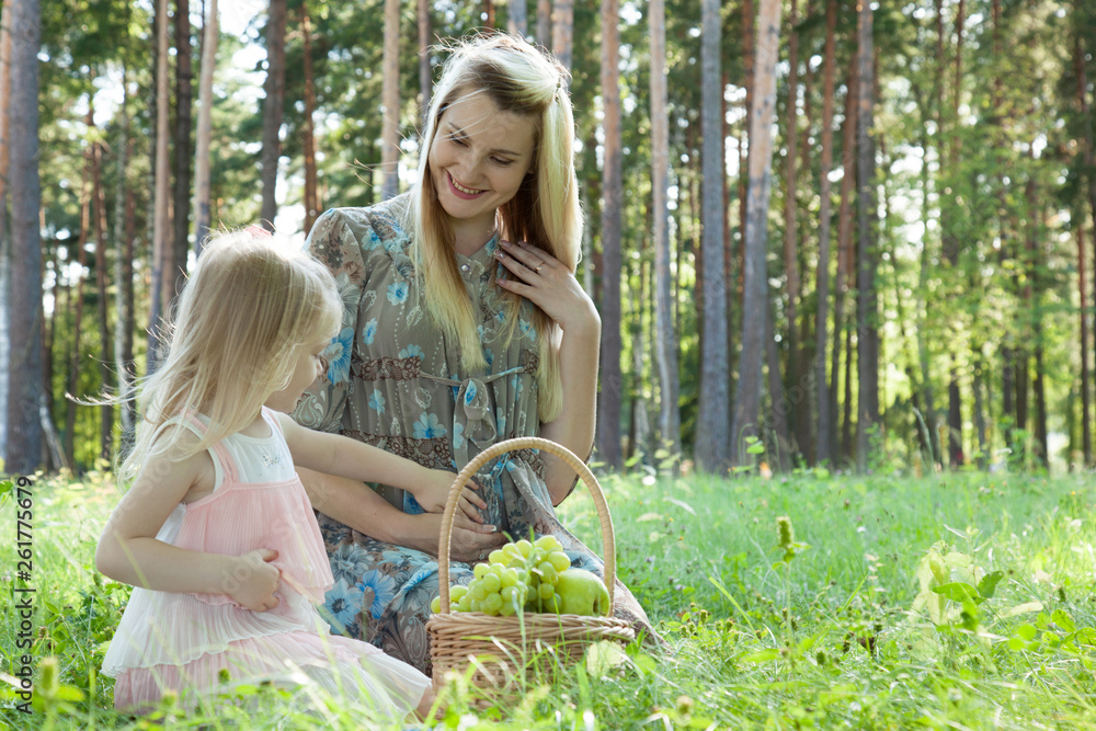 Obraz premium Pregnant young mother with her little daughter outdoors