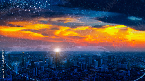 Cityscape at sunrise with connecting line icon with world map in the sky. Connection technology concept.