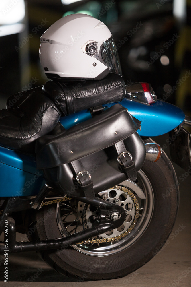 White motorcycle open face helmet laying on back seat of motorbike dark parking lot, nobody White motorcycle open face helmet laying on back seat of motorbike dark parking lot, nobody