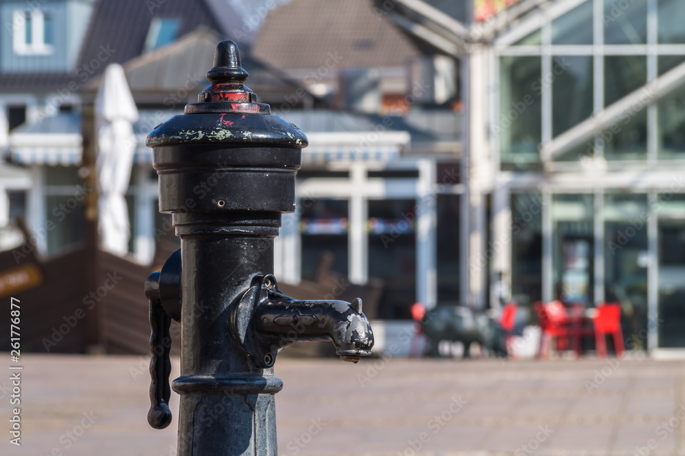Fototapeta premium Old manual iron water pump at marketplace of aurich, germany.