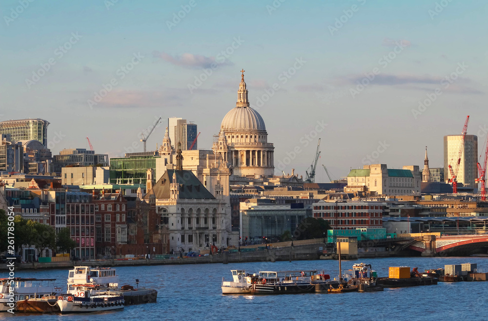 The dome of St. Pauls Cathedral across the Thames river by the early evening sun, London.