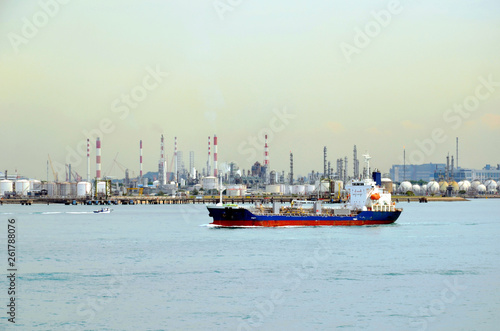 Cargo ship departing from Singapore industrial area.