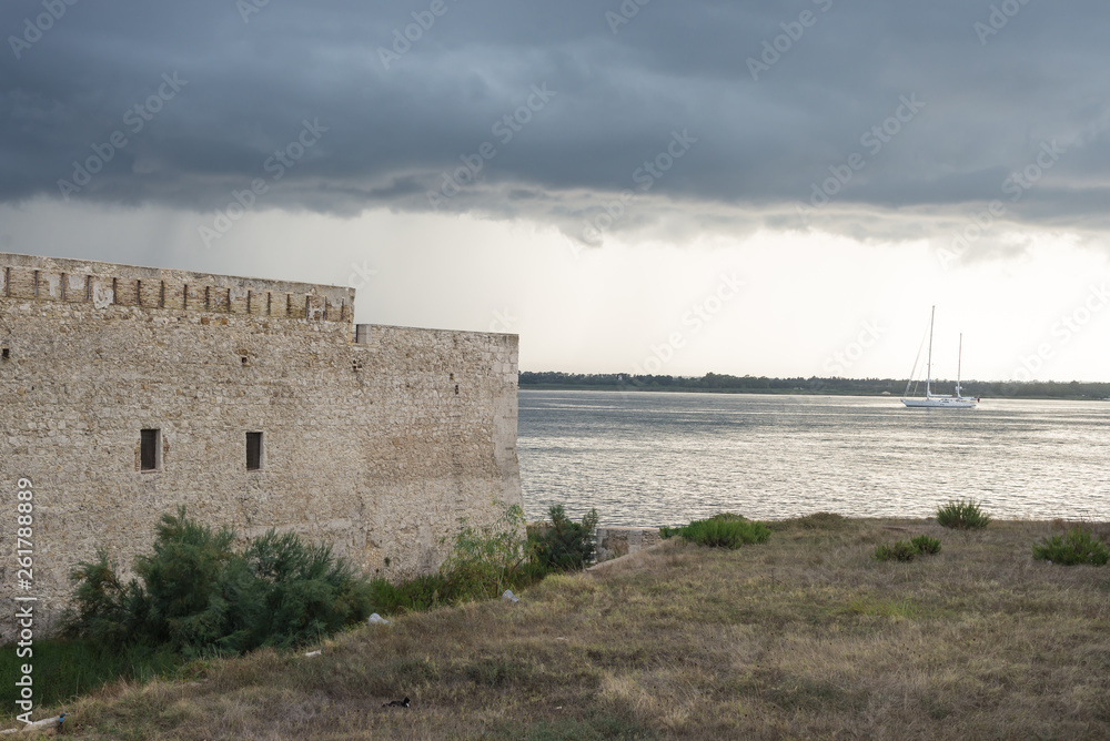 Beautiful view of Maniace castle in Ortigia Syracuse, in front of the sea and sky.