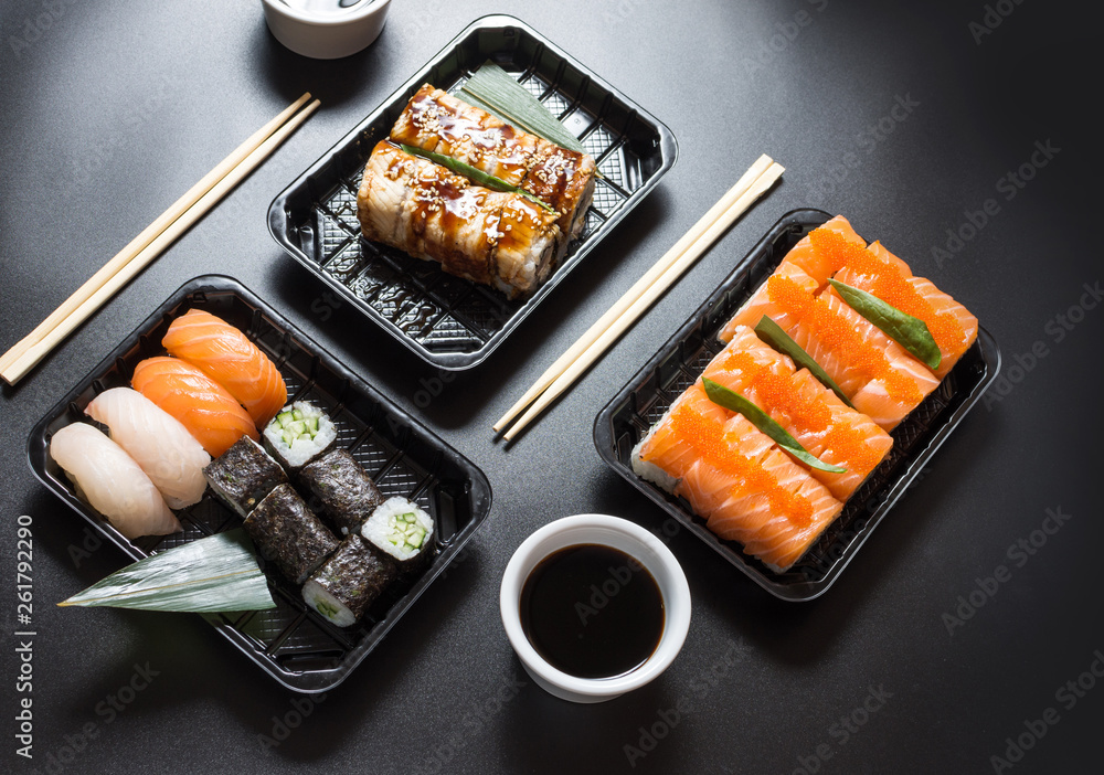 Various kinds of sushi served on black background