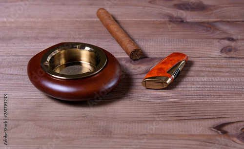 Stylish exquisite ashtray with cigar and lighter on the table