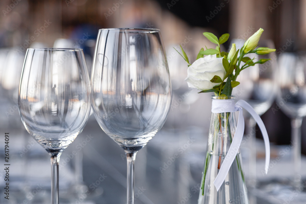 Modern restaurant setting, glass vase with bouquet flowers on