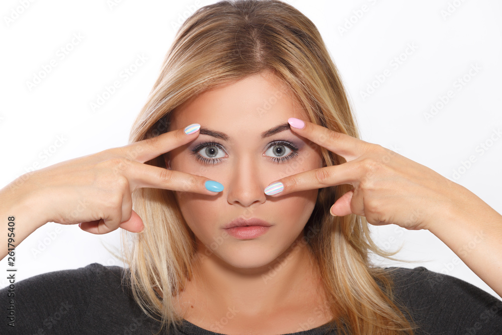 Fototapeta premium Young beautiful girl holding her fingers to her face, showing manicure