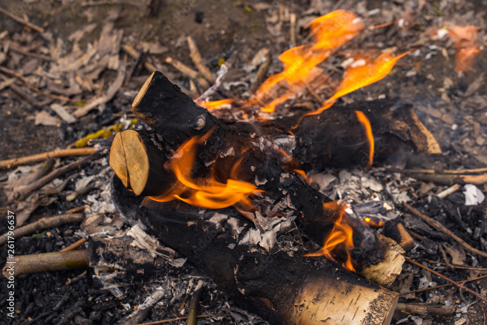 Closeup top view of stack of burning charred wood isolated on ground background. Horizontal color photography. Closeup top view of stack of burning charred wood isolated on ground background. Horizontal color photography.