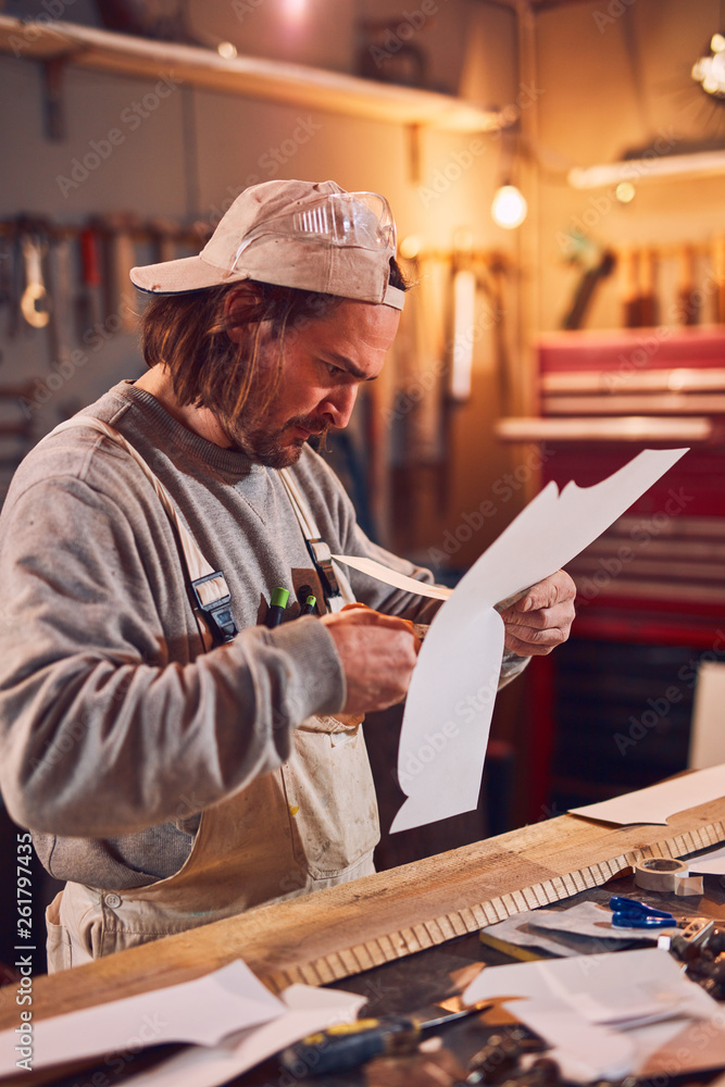 Male carpenter working on old wood in a retro vintage workshop. Male carpenter working on old wood in a retro vintage workshop.