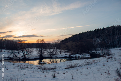 Winter landscape with river and sunset