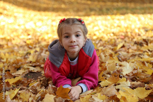 happy little baby girl playing in autumn in yellow leaves