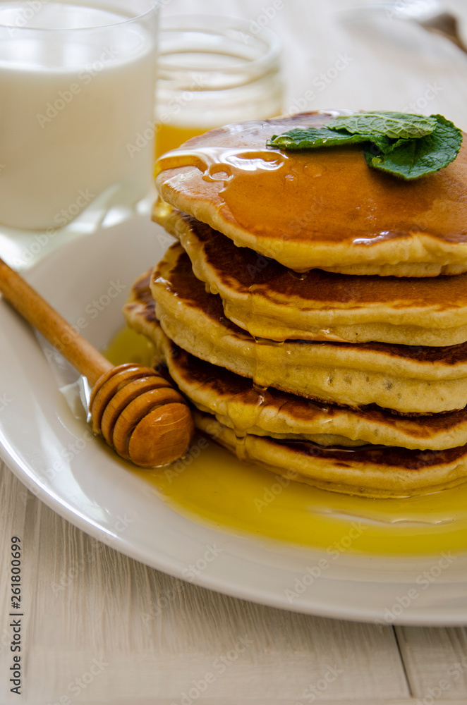 Pancake with milk on a white plate and wooden table. Pancake with milk on a white plate and wooden table.