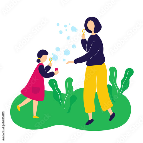Mother blowing soap bubbles with daughter outdoor