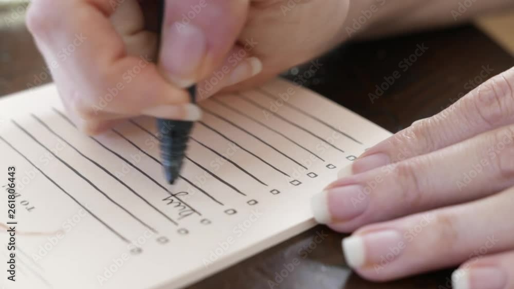 Closeup of hands writing a note. A to-do list. Closeup of hands writing a note. A to-do list.