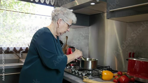 happy senior active woman cooking at home in a modern kitchen