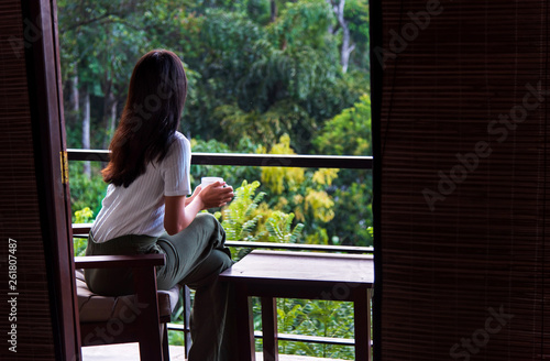 Woman having a cup of tea on the balcony