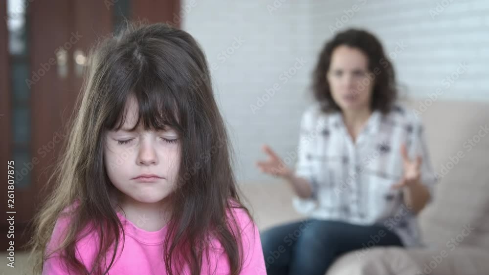 The little girl is depressed. Mother screams at sad little daughter. The little girl is depressed. Mother screams at sad little daughter.