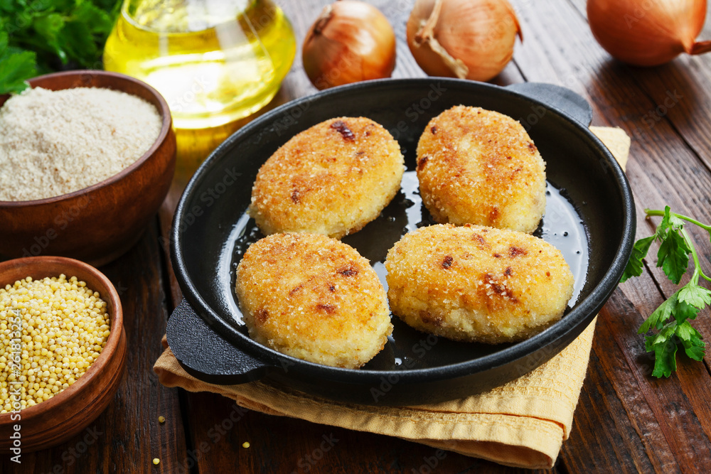 Millet burgerss in a frying pan Millet burgerss in a frying pan