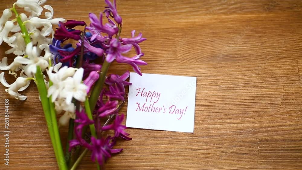 spring beautiful flowers of hyacinth with congratulations for mom on a wooden table spring beautiful flowers of hyacinth with congratulations for mom on a wooden table