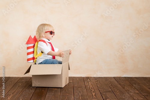 Принти на полотні Happy child playing with toy rocket at home