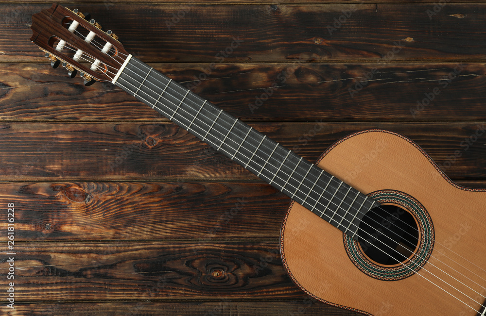 Fototapeta premium Beautiful six - string classic guitar on wooden background, space for text