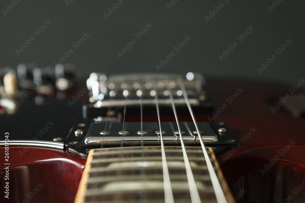 Beautiful six - string electric guitar against dark background, closeup Beautiful six - string electric guitar against dark background, closeup
