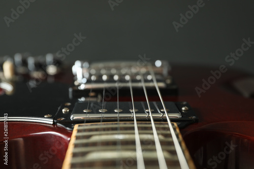 Beautiful six - string electric guitar against dark background, closeup