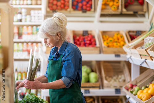 Senior woman working in small grocery store