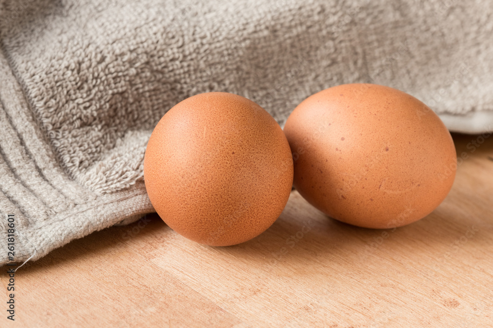 Two brown eggs on a wooden kitchen table. Two brown eggs on a wooden kitchen table.