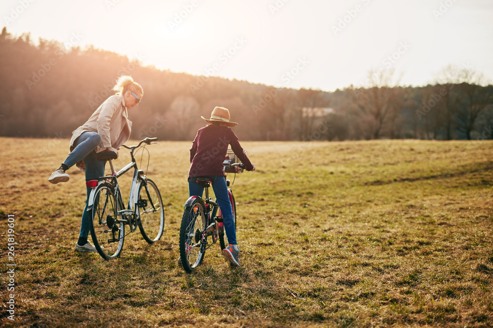 Obraz premium Mother and daughter with bicycles on countryside.