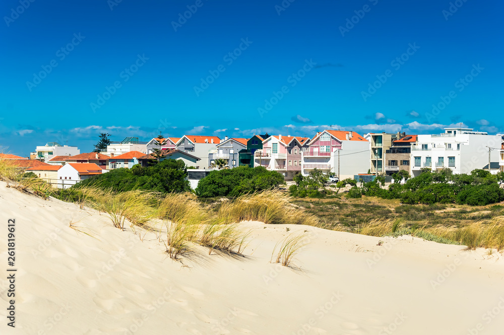 Beach sand dunes and colorful houses in a beach village Costa Nova, Portugal