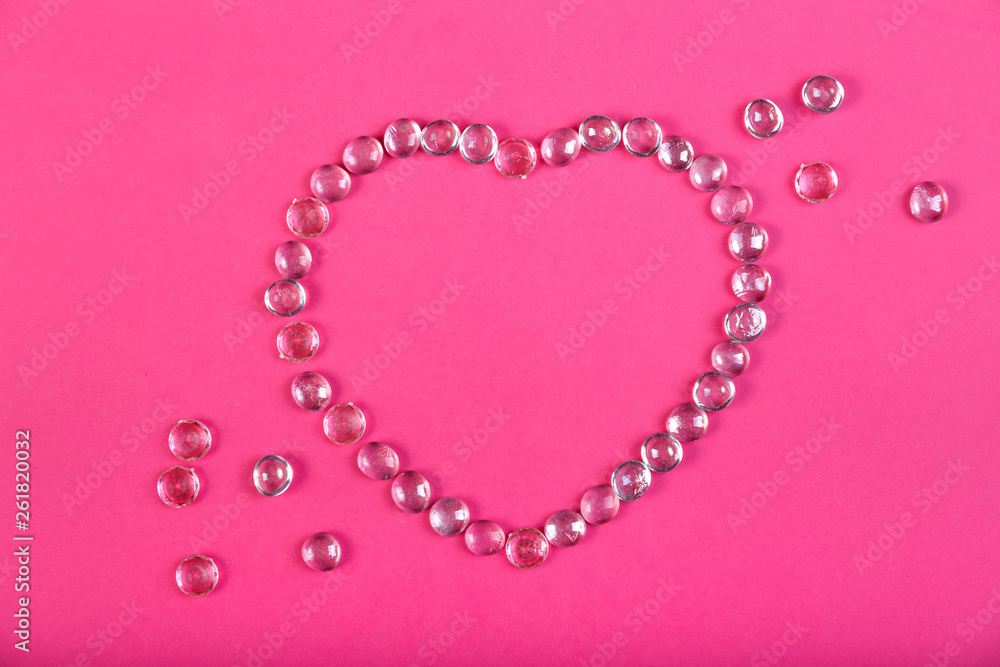 Beaded heart on a pink background.