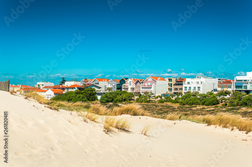 Beach sand dunes and colorful houses in a beach village Costa Nova, Portugal