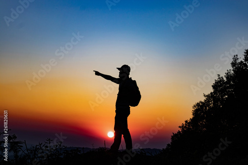 silhouette man on top mountain in sunset