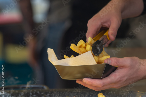 close up of man serving fish and chips on a street food stall  photo
