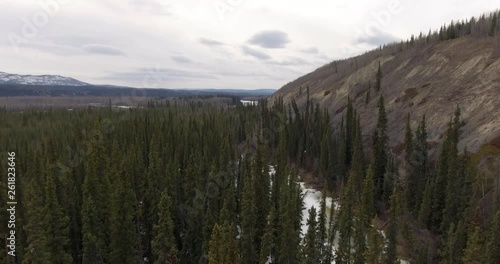 Aerial 4k - Flying the Tintina Trench - Slow tilt down to trees photo