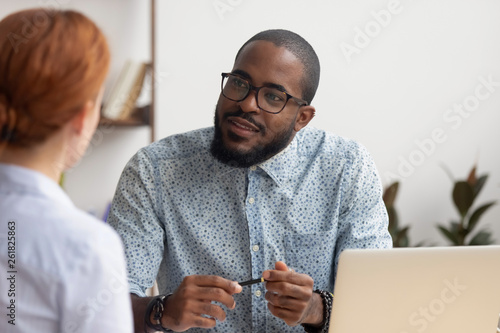 African hr manager listening to caucasian applicant at job interview photo