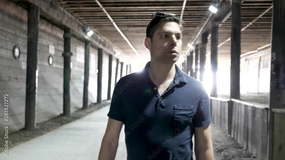 Man walks under wooden bridge on pedestrian crosswalk. Man walks under wooden bridge on pedestrian crosswalk.