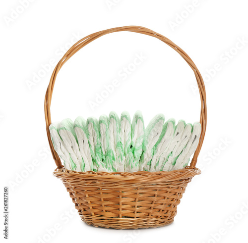 Wicker basket with disposable diapers on white background. Baby accessories