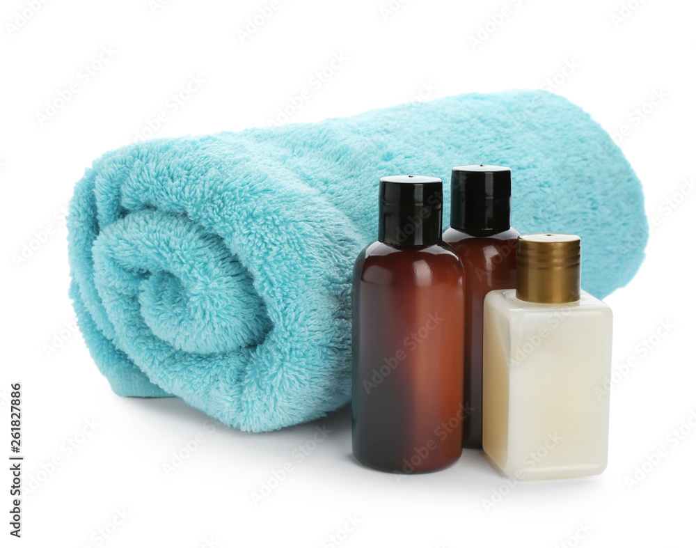 Mini bottles with cosmetic products and towel on white background. Hotel amenities Mini bottles with cosmetic products and towel on white background. Hotel amenities