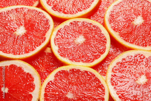 Juicy grapefruit slices as background. Citrus fruit
