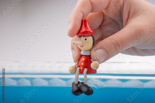 Hand holding Pinocchio on i...